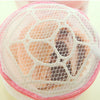A pink reusable mesh bag used for washing lingerie.