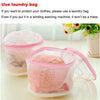 A pink reusable mesh laundry bag filled with clothing, shown on a white surface.