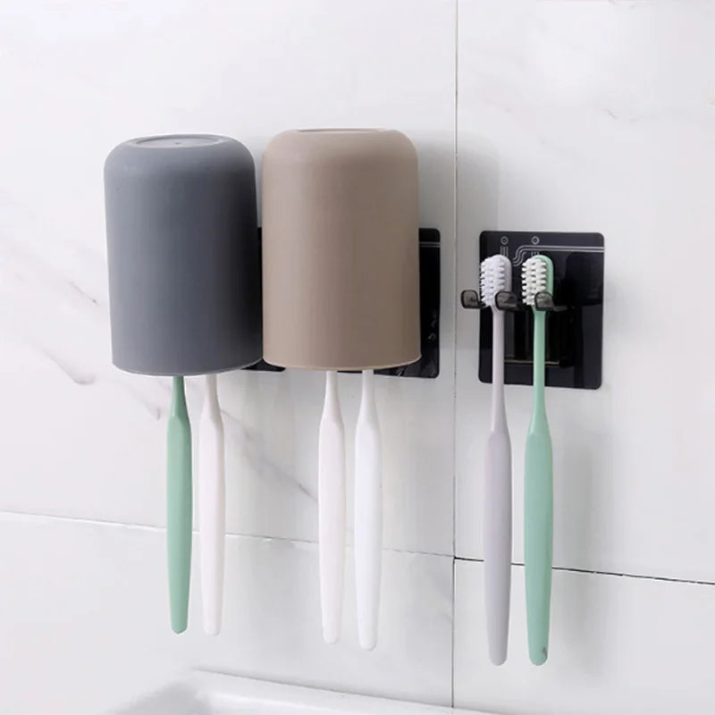 Wall mounted organizer holding a gray cup and three light green toothbrushes.