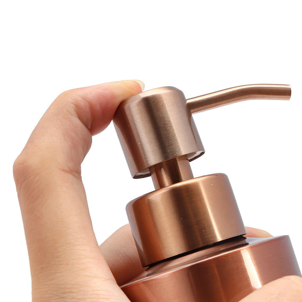 Eine Hand hält eine Sprühflasche für Flüssigseife aus roségoldtem Edelstahl.