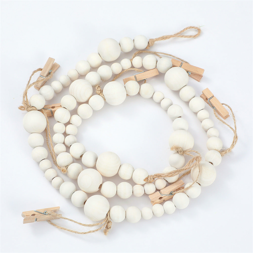 Una guirnalda de cuentas de madera pequeñas, redondas y de color blanco hueso, enhebradas en cordel.