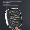 A hand is holding a silver handheld shower head with a textured, perforated nozzle.