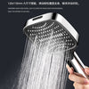A hand is holding a high-pressure handheld shower head, spraying water onto the palm of another hand.