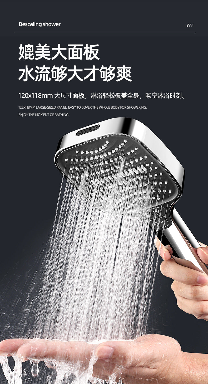A hand is holding a high-pressure handheld shower head, spraying water onto the palm of another hand.