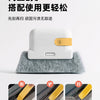 A white multi-purpose groove cleaning brush with a gold accent, shown resting on a gray felt surface.