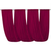 A set of deep magenta sheer chiffon draping fabric curtains hanging across a rod.