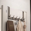A silver over-the-door organizer rack with extended arms mounted on a light gray wall.