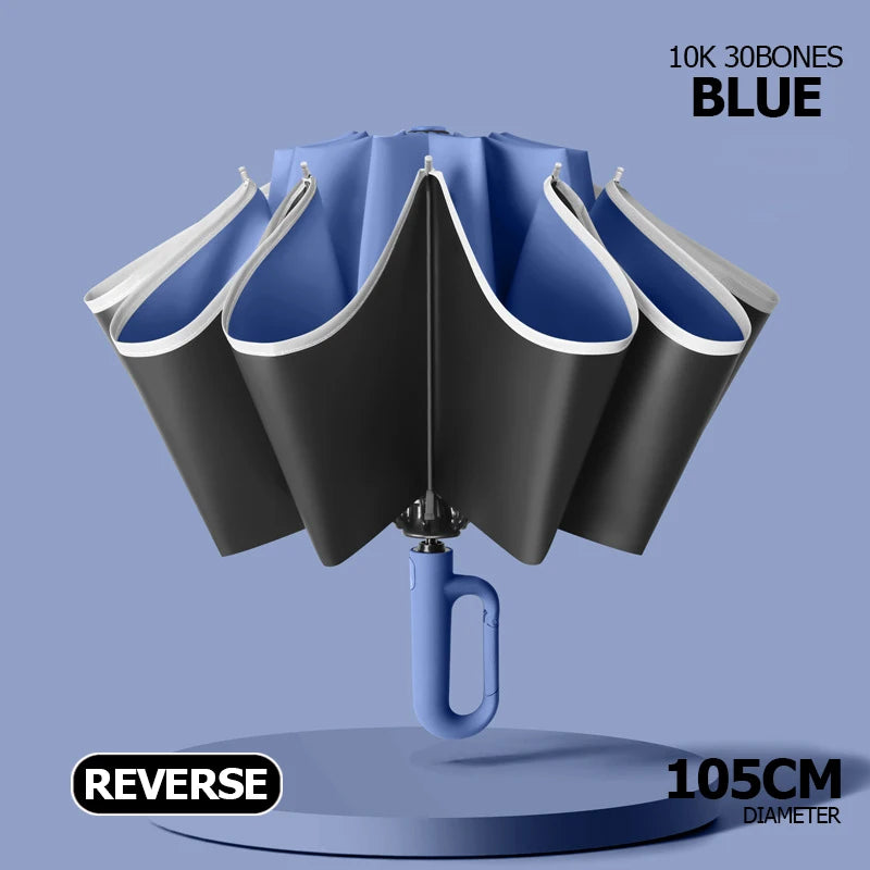 Blue 10K 30bones windproof reflective folding umbrella with a carabiner handle displayed on a stand.
