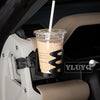 A clear plastic cup with a light brown beverage and a white straw is mounted in a car's interior using a magnetic holder.