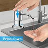 A hand is pressing down on a stainless steel liquid soap dispenser attached to a kitchen faucet.