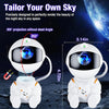 A white astronaut-shaped projector casts a 360 degree galaxy projection onto a dark surface.