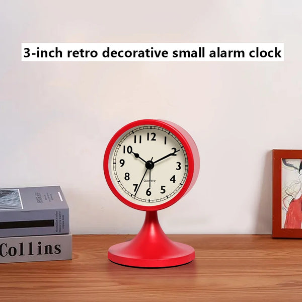 A red 3-inch retro decorative small alarm clock with a black face sits on a wooden table.