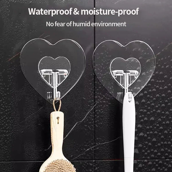 Transparent heart-shaped adhesive hooks for hanging items like spatulas or utensils.