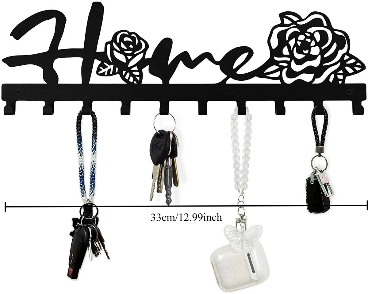 Black rustic metal wall hook key holder with decorative floral cutouts and hanging keys