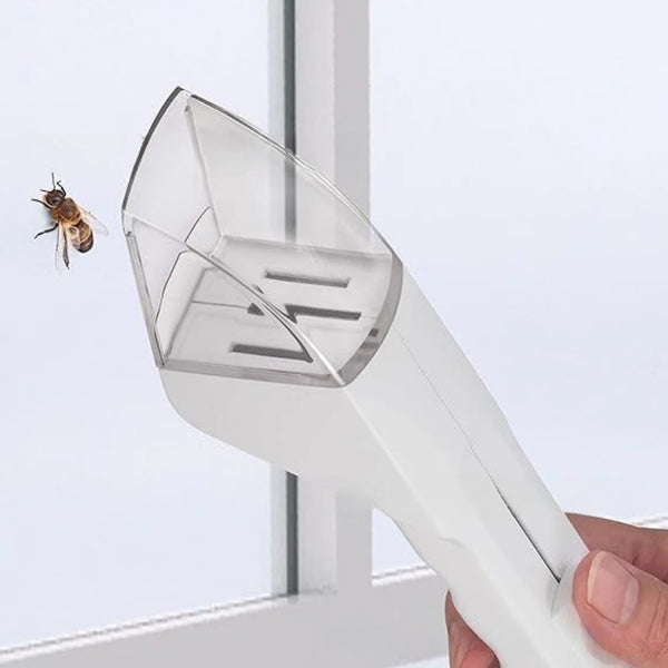 A hand holds a white handheld pest catcher device, designed to capture insects and pests.