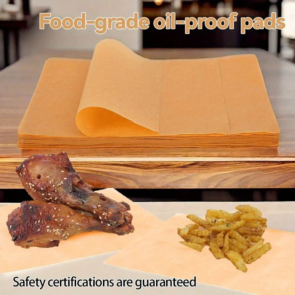 A stack of food-grade oil-proof parchment paper next to cooked chicken and fried potatoes.