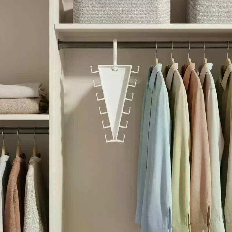 A white multi-hook closet organizer hanger with twelve hooks hanging on a white shelf.