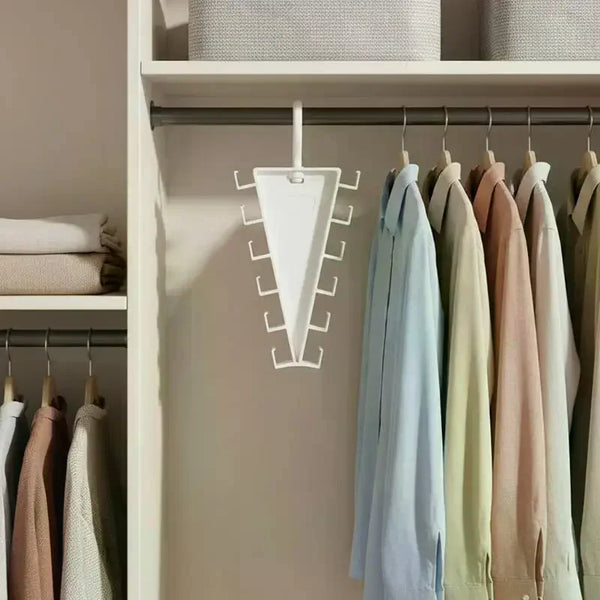 A white multi-hook closet organizer hanger with twelve hooks hanging on a white shelf.