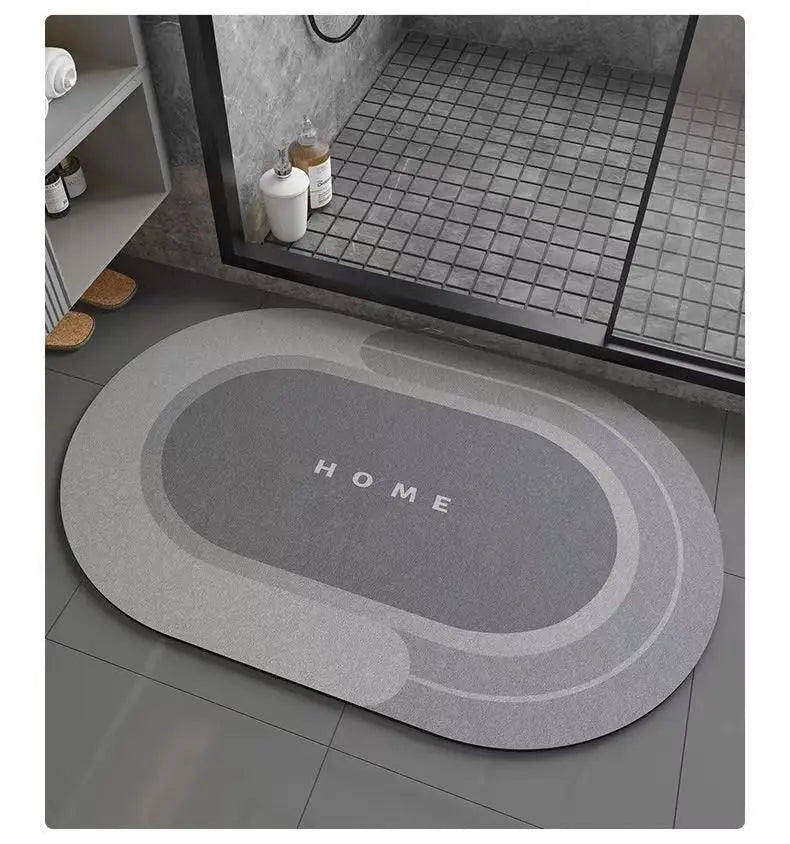 A gray anti-slip floor mat with the word HOME embossed on it placed on a tiled floor near a window.