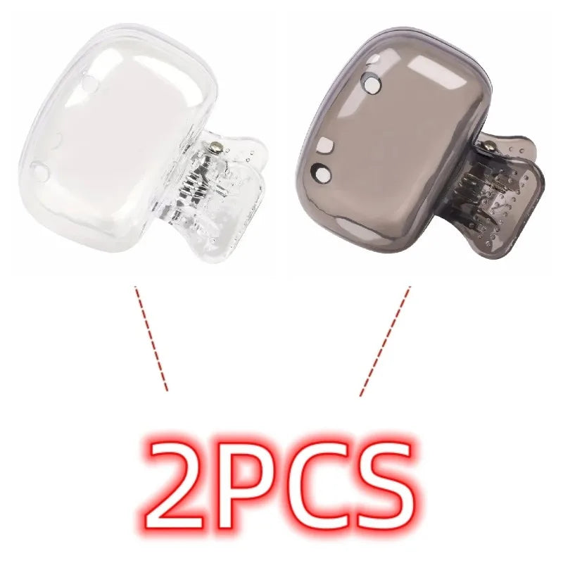 Two reusable silicone brush head covers, one clear and one gray, for electric toothbrushes.