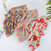 A set of kitchen cleaning cloths in various shades of orange, gray, and pink floral patterns.