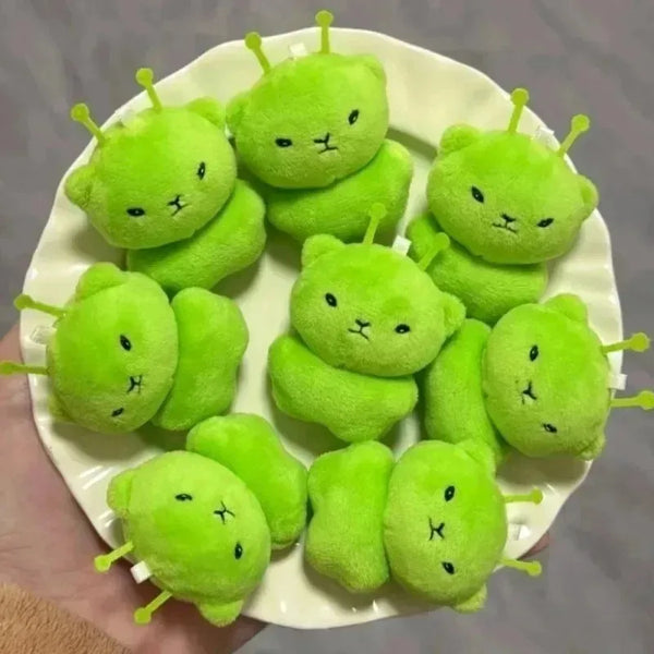 A plate holds six bright green plush cats, likely a Galaxy Cat Plush Keychain for Couples.