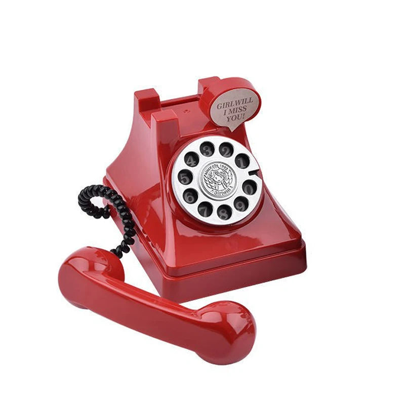A red retro telephone prop with a circular dial and a sign that reads I miss you.