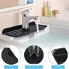 A silver faucet mounted on a black drain mat in a kitchen sink, showing the adjustable gap and foldable design.