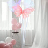 Pink and purple 3D simulated butterfly decorations with balloons in a white draped setting