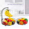 A black metal two-tier fruit basket organizer holding various colorful fruits like bananas, apples, and oranges.
