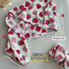 A pink and white strawberry print quick-drying hair towel headscarf is displayed on a white surface.