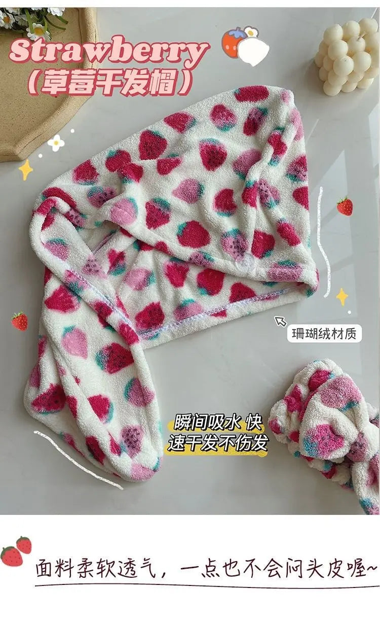 A pink and white strawberry print quick-drying hair towel headscarf is displayed on a white surface.