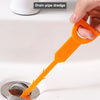 An orange drain pipe dredge tool is shown cleaning a drain, highlighting its ease of use and strong water features.