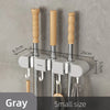 A set of three wall mounted broom holders with wooden handles and silver rods in a gray finish.