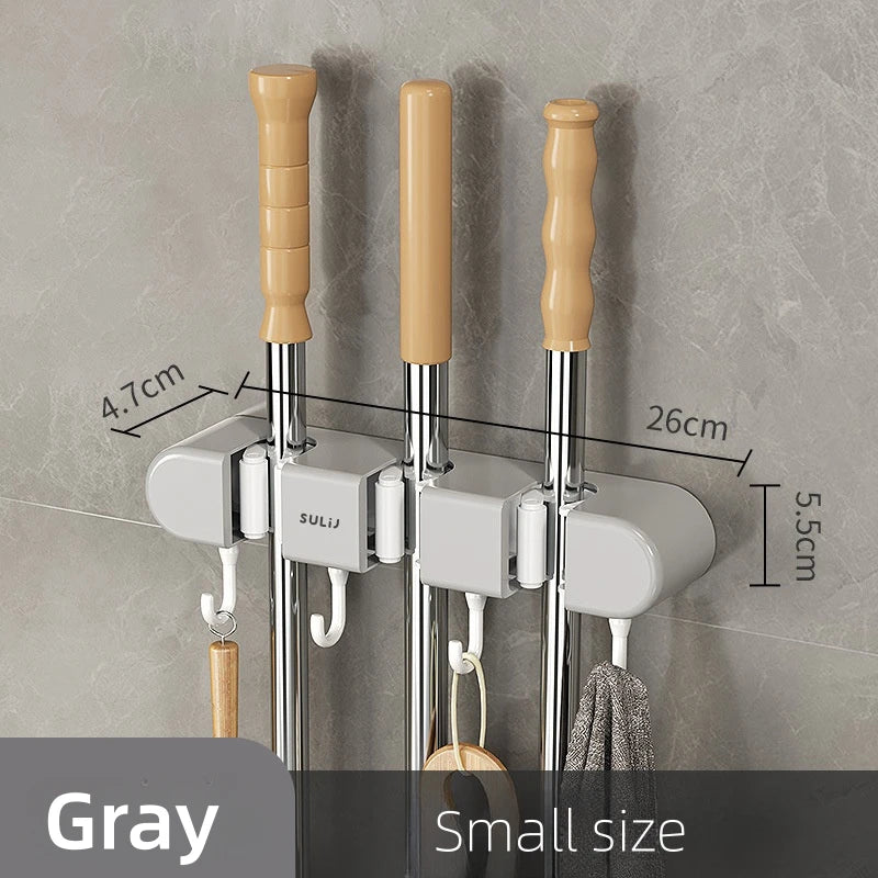 A set of three wall mounted broom holders with wooden handles and silver rods in a gray finish.