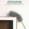 A gray, fluffy extendable microfiber duster is shown next to a framed picture.