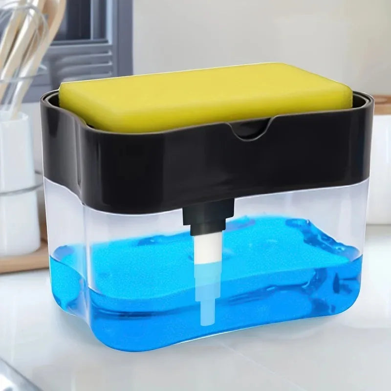 A clear dispenser holds blue liquid soap and a yellow sponge, featuring a black lid and a white dispensing nozzle.