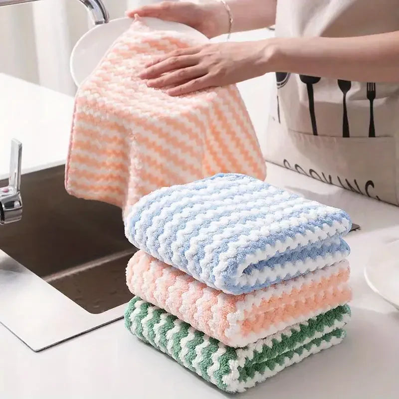 Stack of pink and blue coral fleece cleaning cloths being used near a kitchen sink.