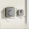 A gray retractable wire clothesline with a circular handle is mounted on a white wall.