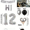Un juego de globos con números y corazones de foil plateado y negro para decoración de cumpleaños.