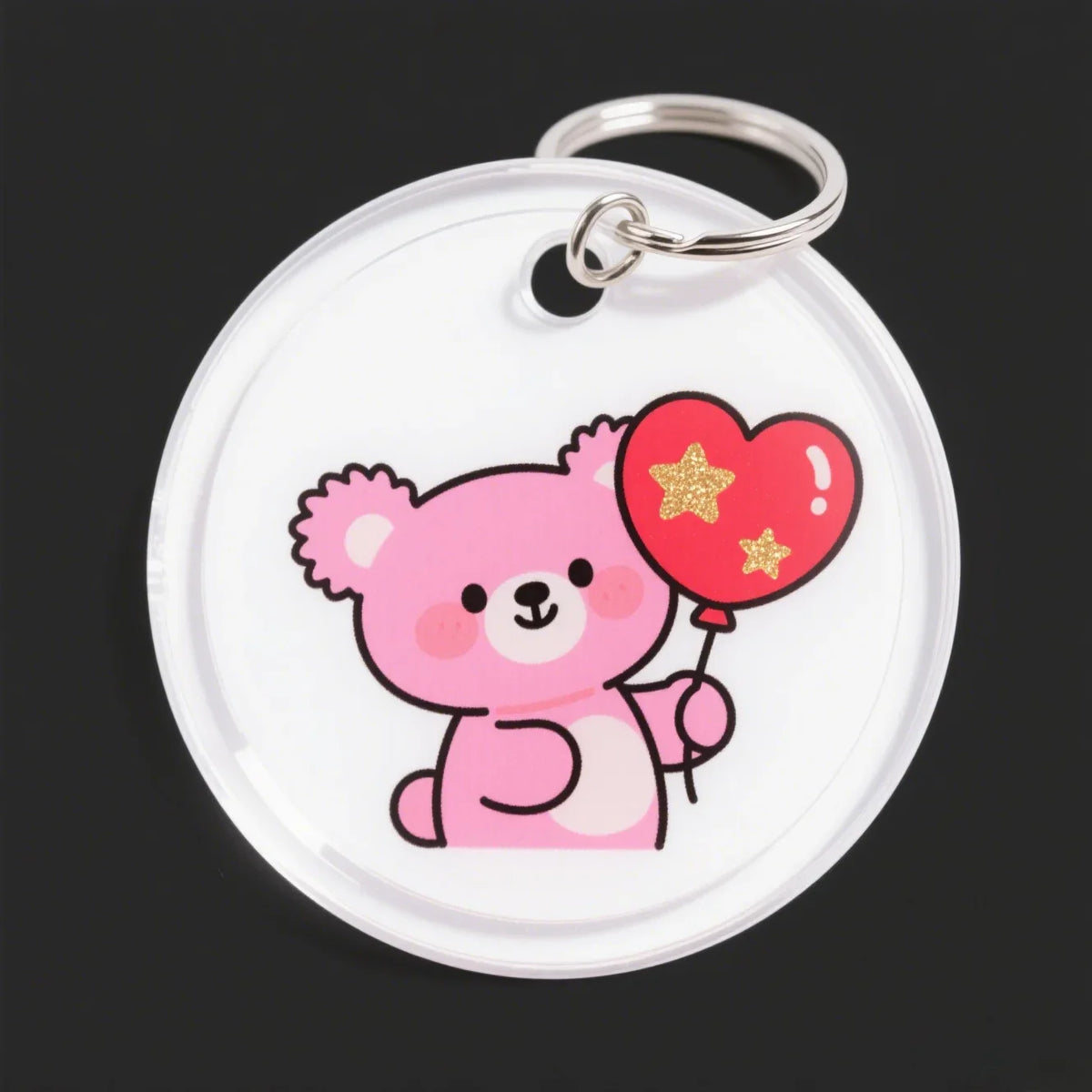 A clear acrylic keychain featuring a pink teddy bear hugging a red heart with gold stars.