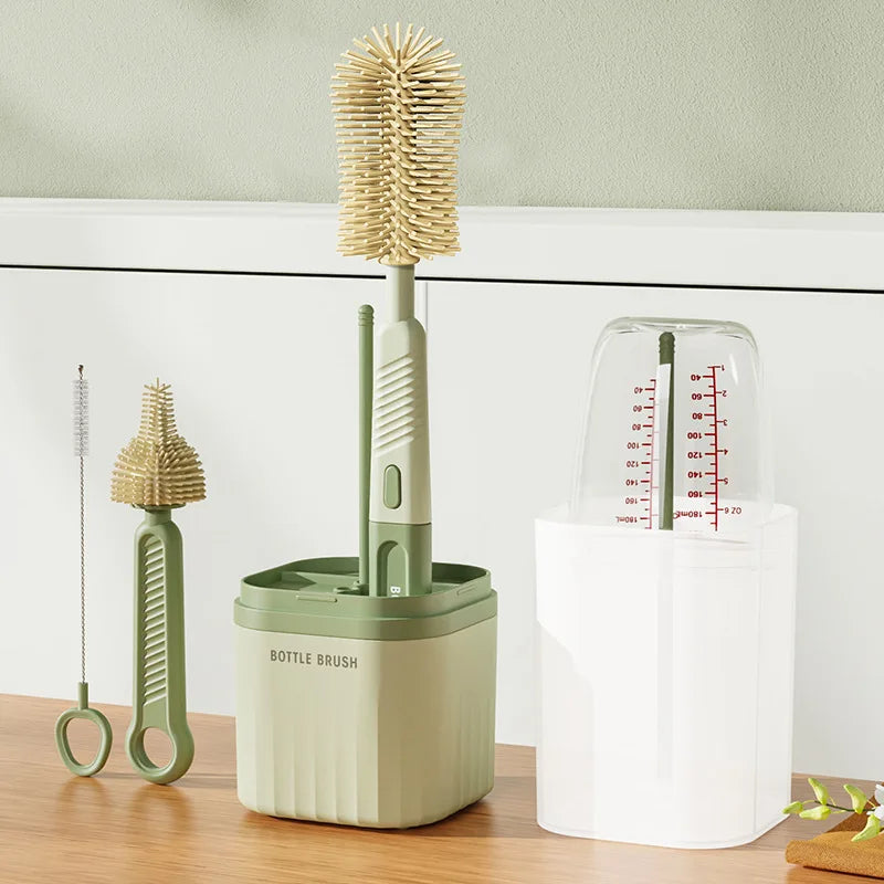 A set of silicone bottle brushes and a drying rack in light green and white on a wooden surface.