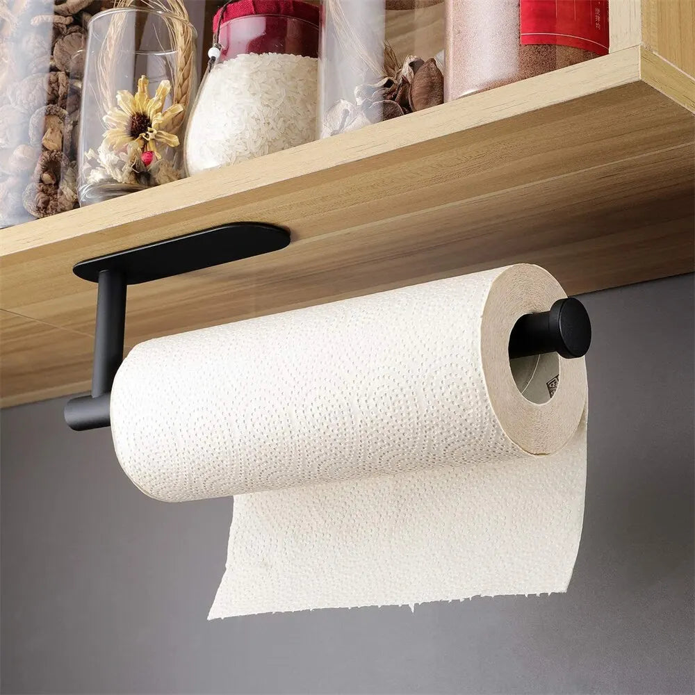 A roll of white paper towels is mounted on a black holder beneath a wooden shelf.