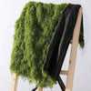A dark green artificial moss garland draped over a wooden easel.