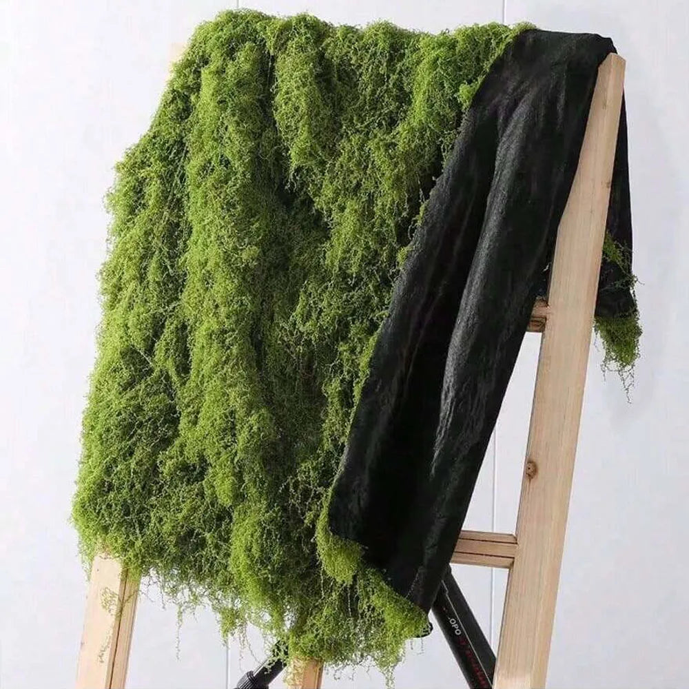 A dark green artificial moss garland draped over a wooden easel.
