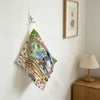 A hand wiping towel featuring a Totoro cartoon design hanging on a white wall.