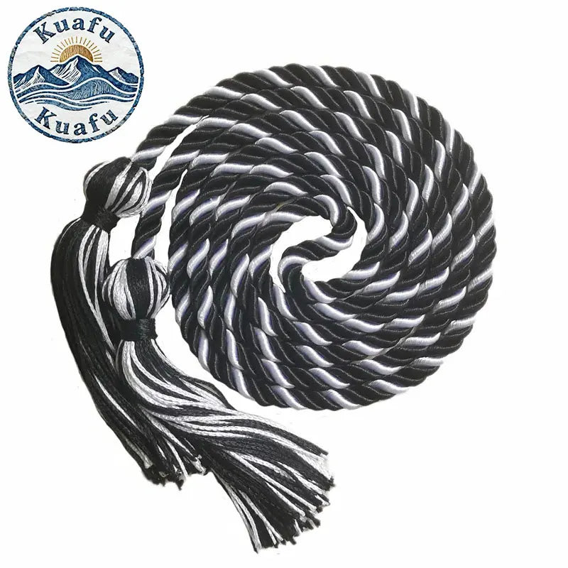 A black and white graduation honor cord with tassel ends coiled in a spiral.