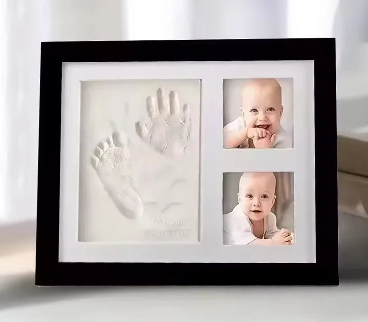 Recuerdo enmarcado de negro con la huella de la mano de un bebé y una foto de un bebé sonriente.