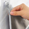 A hand is opening a foldable hanging laundry basket organizer, showing the mesh fabric and a clip.