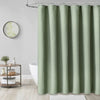 A floor-length, solid sage green waterproof shower curtain hanging on a metal rod.